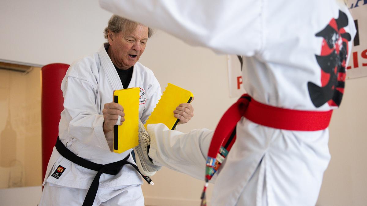 Gerry Blanck, left, holds a breakable board as Margaret Muller, right, kicks it at Gerry Blanck's Martial Arts Center on Monday, May 11, 2026, in Pacific Palisades, California. Blanck has returned to the Palisades after his home and dojo burned last year during the 2025 wildfires and will have a grand opening at his new location on June 1, 2026. (Kayla Bartkowski/Los Angeles Times/TNS)
