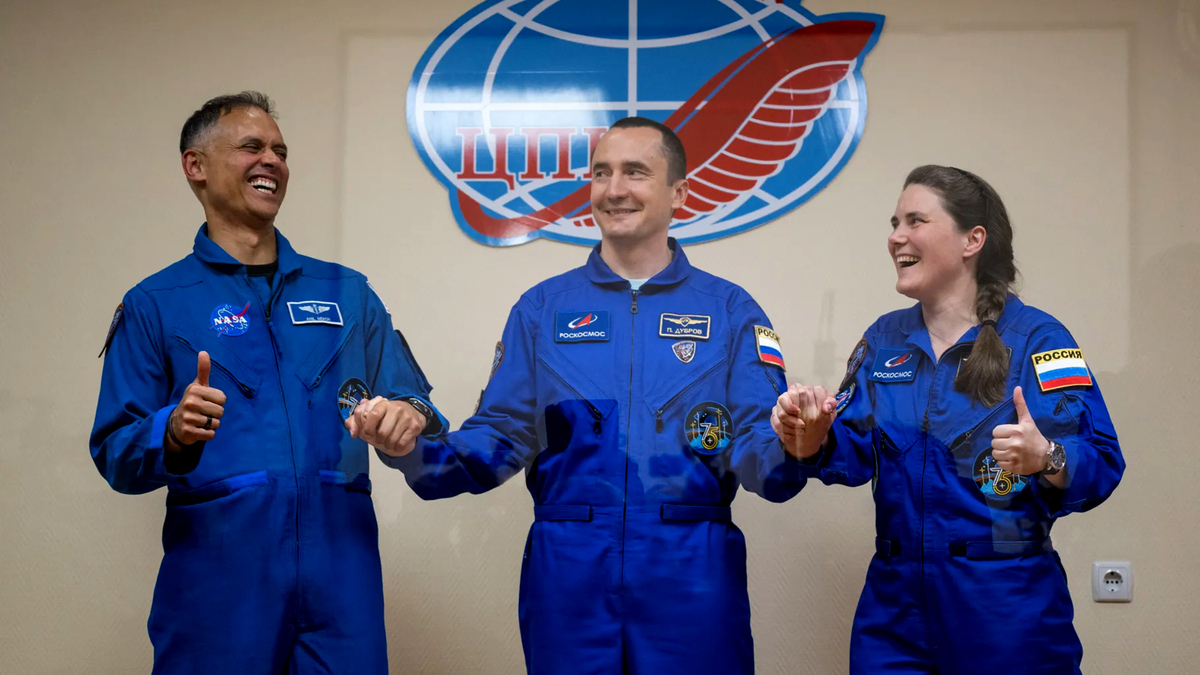 Expedition 75 crew members: NASA astronaut Anil Menon, left, Roscosmos cosmonauts Pyotr Dubrov, and Anna Kikina, right, are seen in quarantine, behind glass, during a press conference, Monday, July 13, 2026 at the Cosmonaut Hotel in Baikonur, Kazakhstan. Menon, Dubrov, and Kikina are scheduled to launch aboard the Soyuz MS-29 spacecraft to the International Space Station on July 14. (Bill Ingalls/NASA/TNS)