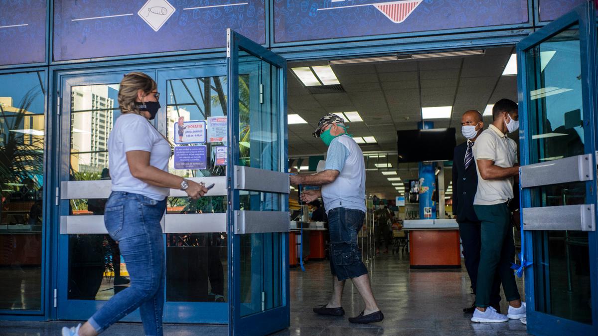 Gente con mascarillas en medio de la pandemia del nuevo coronavirus entra a una tienda de alimentos que acepta dólares estadounidenses en La Habana, Cuba, el lunes 20 de junio de 2020. (AP Foto/Ramon Espinosa)