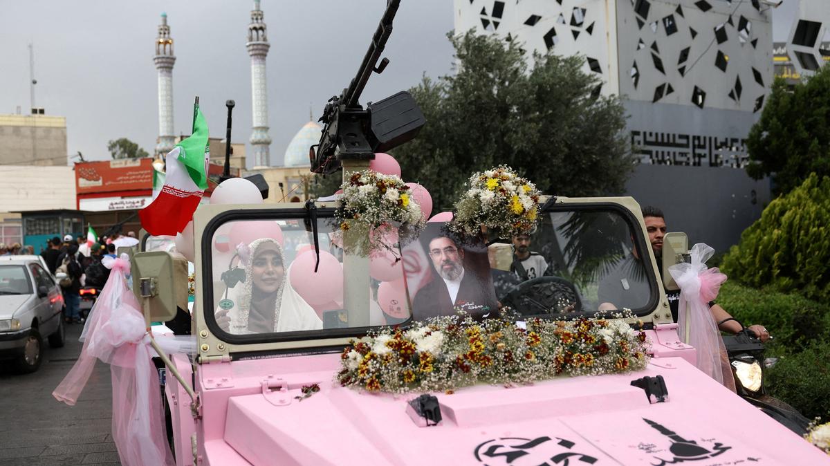 An Iranian couple arrive on a military vehicle during a public wedding ceremony called "Sacrificed couple wedding",  in Tehran, Iran, May 18, 2026. Majid Asgaripour/WANA via REUTERS