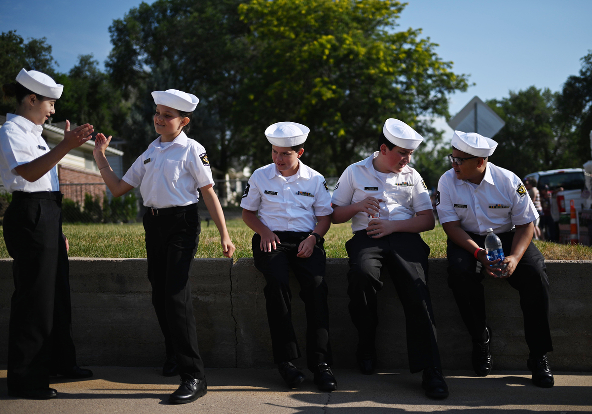Members of the Navy League Cadet Corps exchange a high five while awaiting the start of Greeley Stampede's Independence Day parade in Greeley, Colo., July 4, 2026. America celebrates the 250th anniversary of its independence today, with people from one end of the country to the other marking the milestone with fireworks, parades and concerts. (Mark Makela/The New York Times)