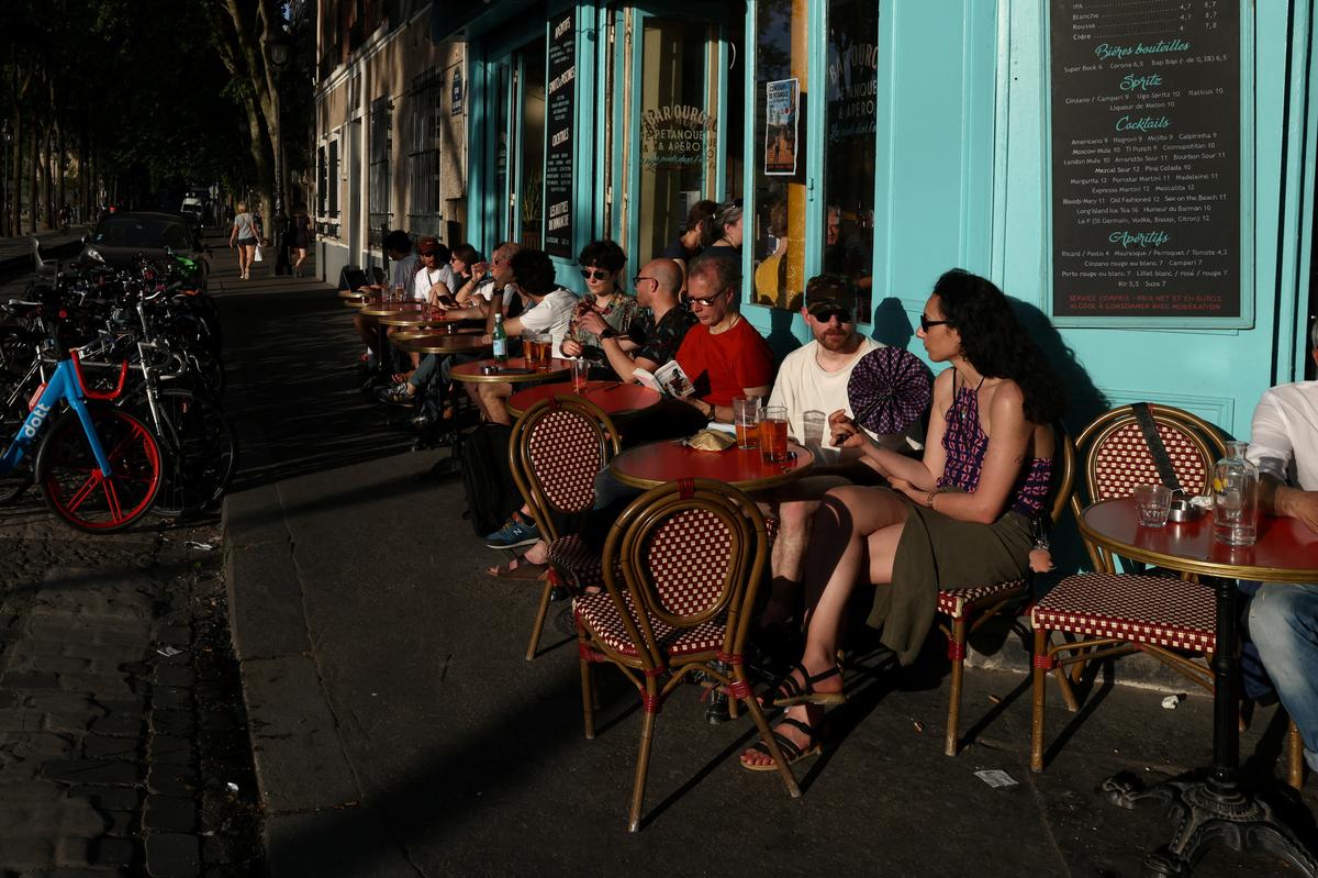 People gather on a terrace on the Canal de l'Ourcq, as temperatures reached up to 35 degrees during a period of hot weather in Paris, France, May 25, 2026. REUTERS/Tom Nicholson
