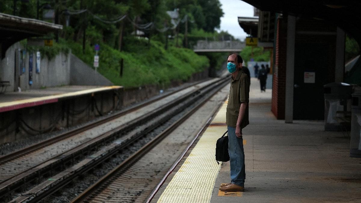 A commuter stands in front of empty train tracks at the Bayside station, a Long Island Rail Road station, as commuters wait for delayed trains in the Queens borough of New York City, U.S., August 1, 2025. REUTERS/Shannon Stapleton