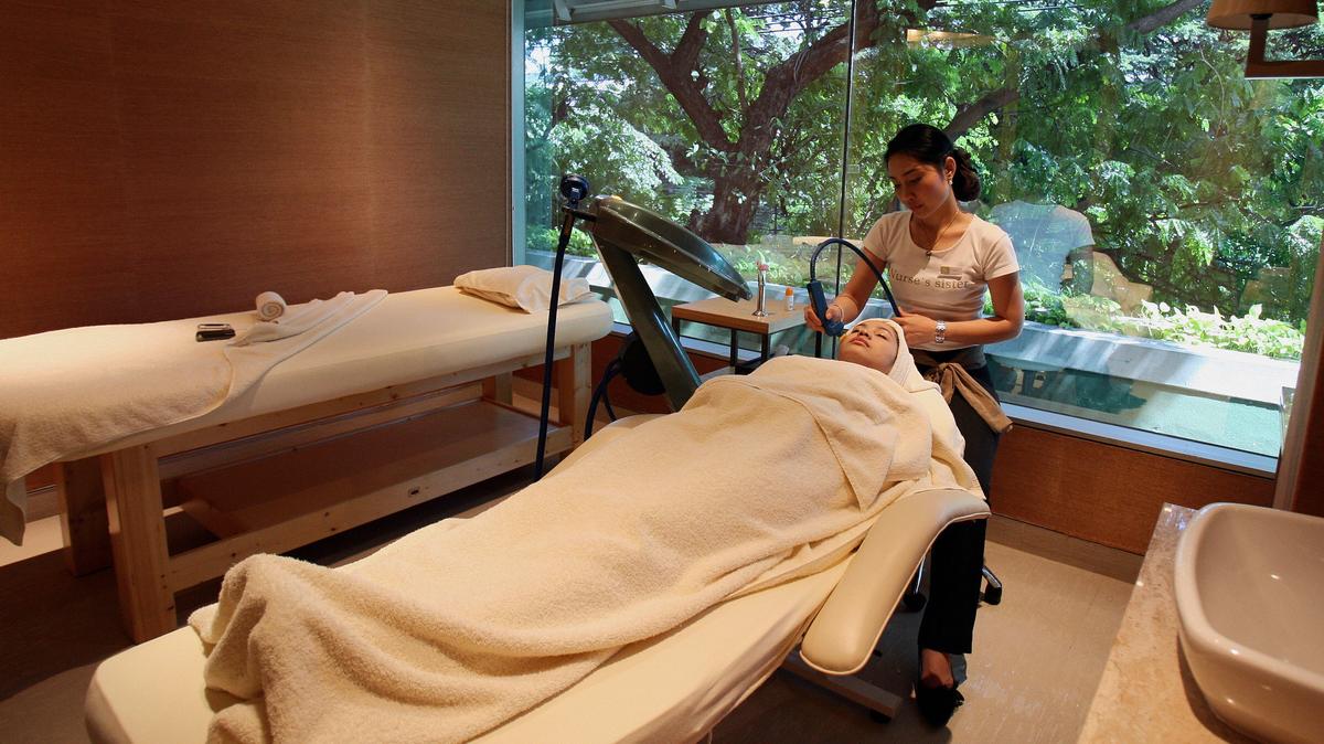 Bangkok, THAILAND:  TO GO WITH STORY: AFPLifestyle-health-Thailand-Tourism  A Thai therapist gives facial treatment of deep laser stimulation to a client at S Medical Spa in central Bangkok, 26 October 2006.  Medical services in Thailand brought in 23.1 billion baht (578 million US dollars) in 2005 and revenue is expected to increase to 27.4 billion baht in 2006. Thailand has also become a medical and spa destination for foreigners.  In 2005, 4.6 million visitors came to Thailand for spa services and 1.28 million hospital patients were international.  AFP PHOTO/ Saeed KHAN  (Photo credit should read SAEED KHAN/AFP via Getty Images)