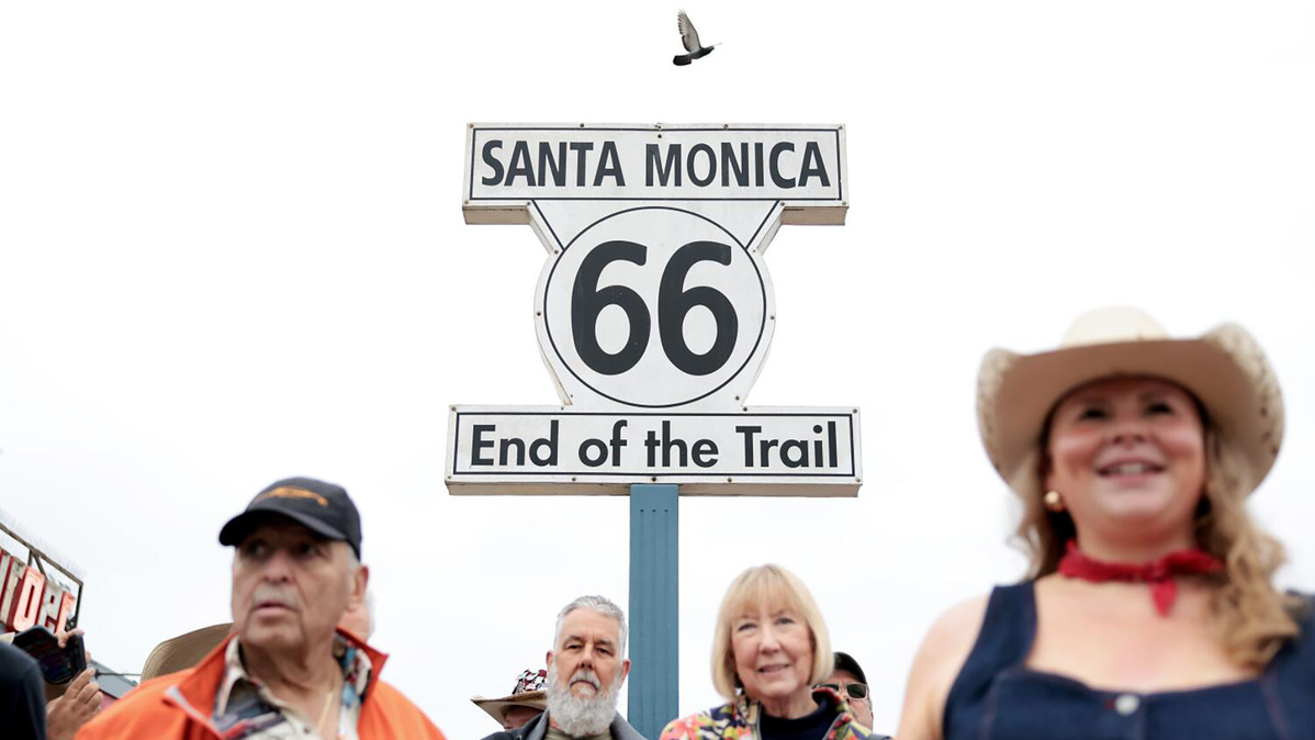 Participants in a caravan from Santa Monica Pier to Chicago gather at the sign on the Santa Monica Pier to kick off the trip, in celebration of the centennial of Route 66, on Saturday, June 6, 2026, in Santa Monica, California. (Christina House/Los Angeles Times/TNS)