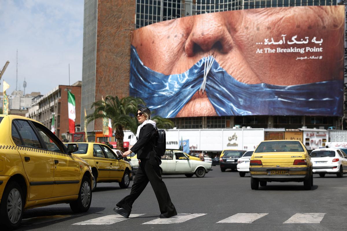 A woman walks past an anti-U.S. billboard depicting U.S. President Donald Trump and the Strait of Hormuz, in Tehran, Iran, May 2, 2026. Majid Asgaripour/WANA (West Asia News Agency) via REUTERS ATTENTION EDITORS - THIS PICTURE WAS PROVIDED BY A THIRD PARTY