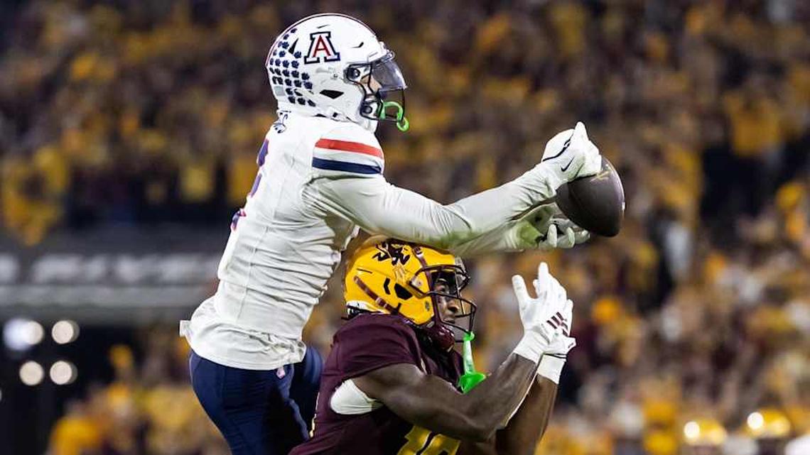  Nov 28, 2025; Tempe, Arizona, USA; Arizona Wildcats defensive back Treydan Stukes (2) intercepts the ball against Arizona State Sun Devils wide receiver Jaren Hamilton (16) in the second half during the 99th Territorial Cup at Mountain America Stadium. Mandatory Credit: Mark J. Rebilas-Imagn Images | Mark J. Rebilas-Imagn Images 