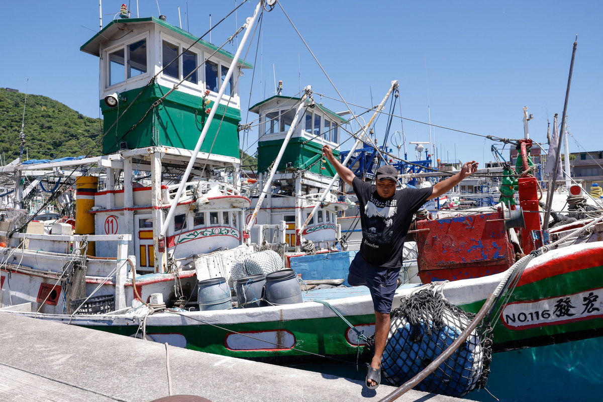 A fisherman jumps from a fishing boat at a fishing harbour as Typhoon Bavi approaches Taiwan in Yilan, Taiwan, July 9, 2026. REUTERS/Ann Wang