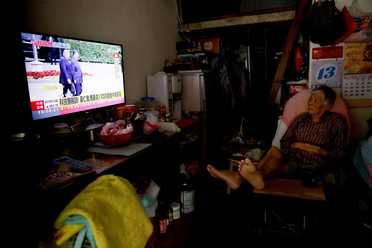 A resident watches a Taiwan television live broadcast of a meeting between U.S. President Donald Trump and Chinese President Xi Jinping at home in Taipei, Taiwan, May 14, 2026. REUTERS/Ann Wang