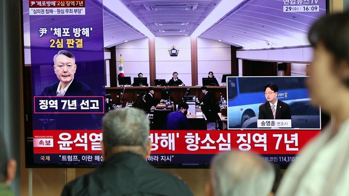 People at Seoul Station watch a live broadcast of a sentencing hearing for former President Yoon Suk Yeol on Wednesday. An appeals court increased Yoon's sentence to seven years in prison on obstruction of justice and other charges. Photo by Yonhap