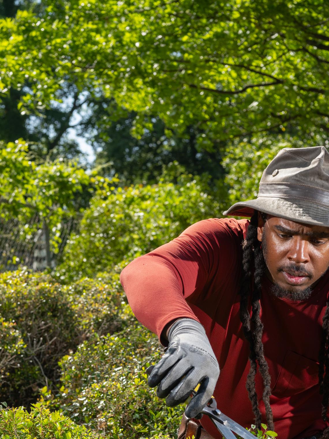 FILE -- Michael Gibson, a topiary artist, who became the first artist in residence at Pearl Fryar's garden in 2021, at Edisto Discovery Park, in Columbia, S.C., April 14, 2025. Fryar, a charismatic factory worker and self-taught topiary artist who turned a former cornfield in South Carolina into a world-famous garden featuring shrubs and trees that he coaxed into towering Seussian swirls, enticing Cubist forms and other uncanny shapes, drawing pilgrims from around the globe and raising the fortunes of his small community, died on Saturday, April 4, 2026, at his home in Bishopville, S.C. He was 86. (Elizabeth Bick/The New York Times)