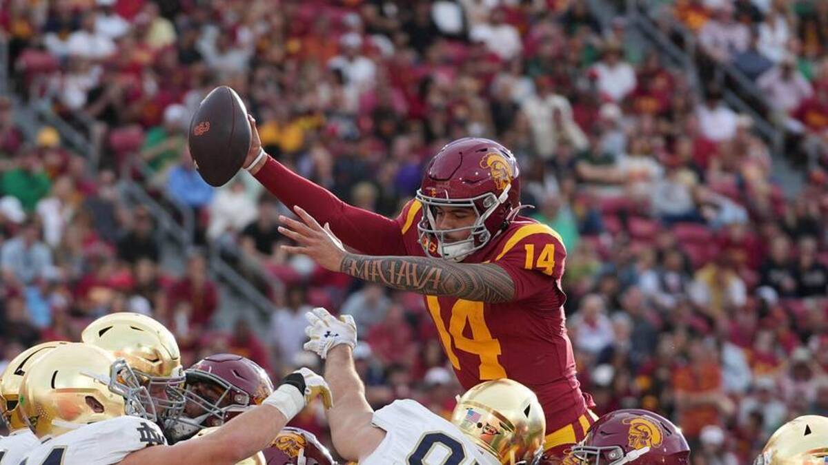  Nov 30, 2024; Los Angeles, California, USA; Southern California Trojans quarterback Jayden Maiava (14) scores on a 1-yard touchdown run against the Notre Dame Fighting Irish in the second half at United Airlines Field at Los Angeles Memorial Coliseum. Mandatory Credit: Kirby Lee-Imagn Images | Kirby Lee-Imagn Images 