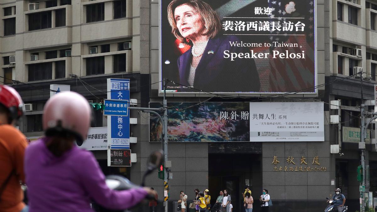 People walk past a billboard welcoming U.S. House Speaker Nancy Pelosi, in Taipei, Taiwan, on Aug. 3.