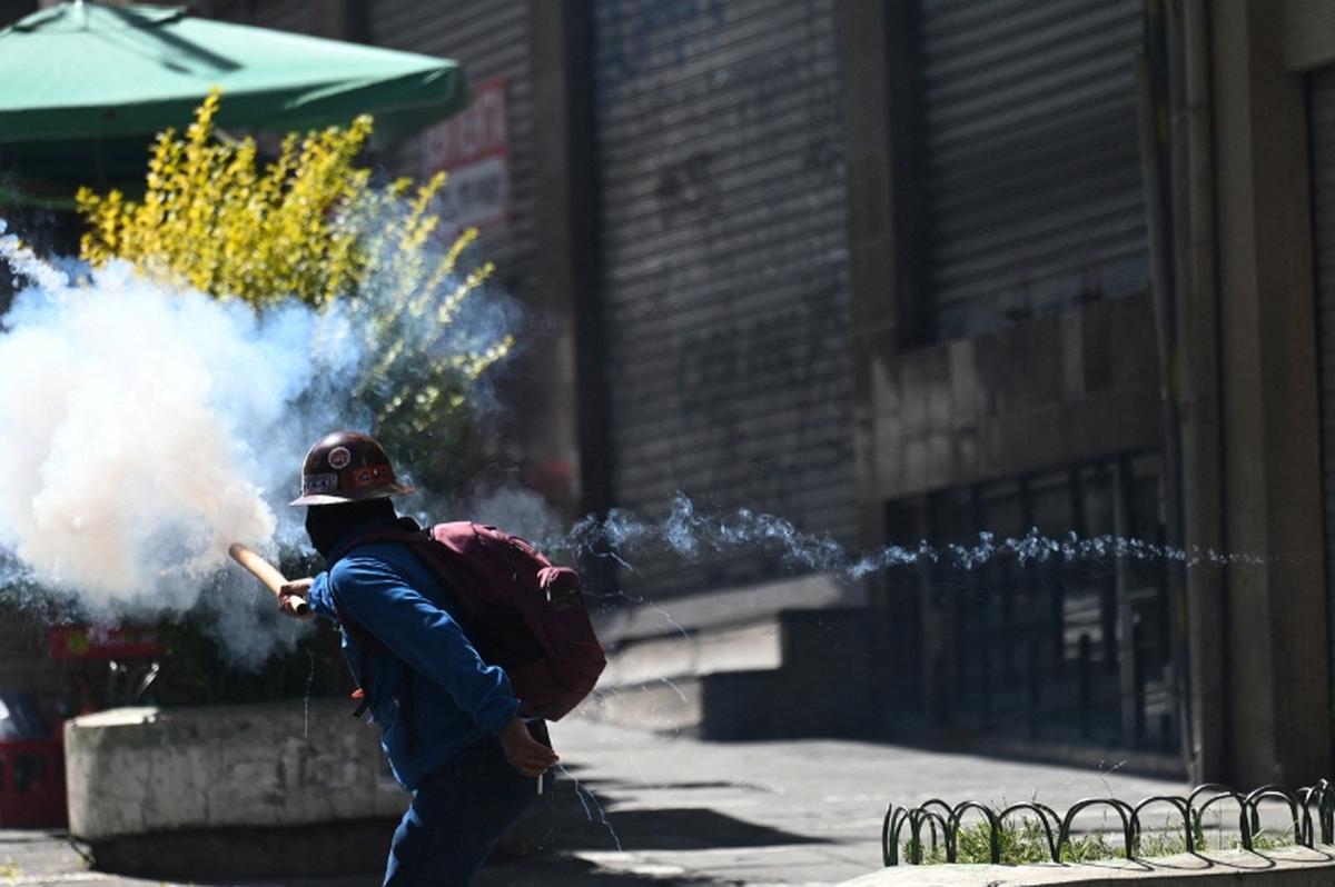 A demonstrator throws a smoking projectile during a march calling for the resignation of Bolivia's President Rodrigo Paz, as the country's economic and fuel crisis worsens due to a shortage of U.S. dollars and falling domestic energy production, in La Paz, Bolivia, May 18, 2026. REUTERS/Claudia Morales
