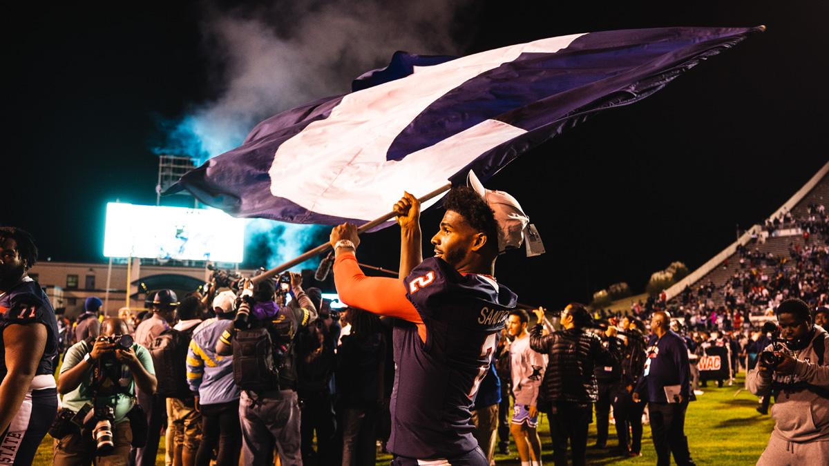  Shedeur Sanders plants a Jackson State flag after JSU beats Southern in the 2022 SWAC Championship Game.