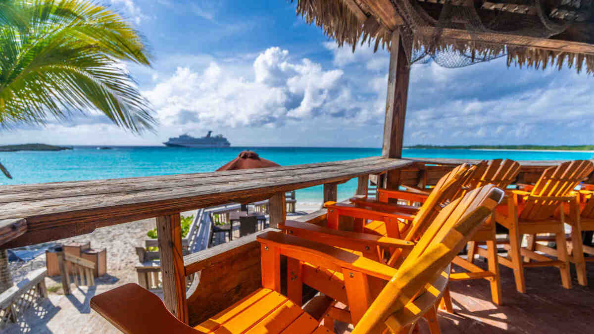 A view of a Carnival cruise ship from a beach bar at Half Moon Cay in The Bahamas.