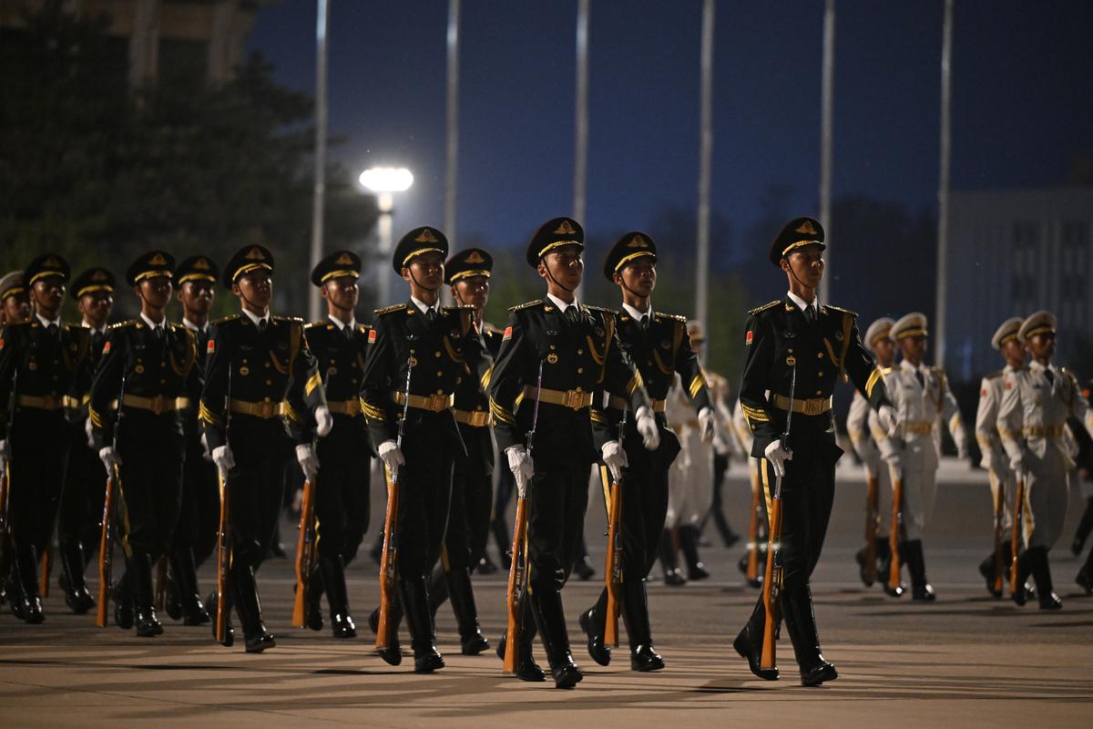 Members of a Chinese military honor guard arrive to welcome President Donald Trump to Beijing Capital International Airport in Beijing, China, on Wednesday, May 13, 2026. Trump is in China for a two-day summit with China's leader, Xi Jinping. (Kenny Holston/The New York Times)