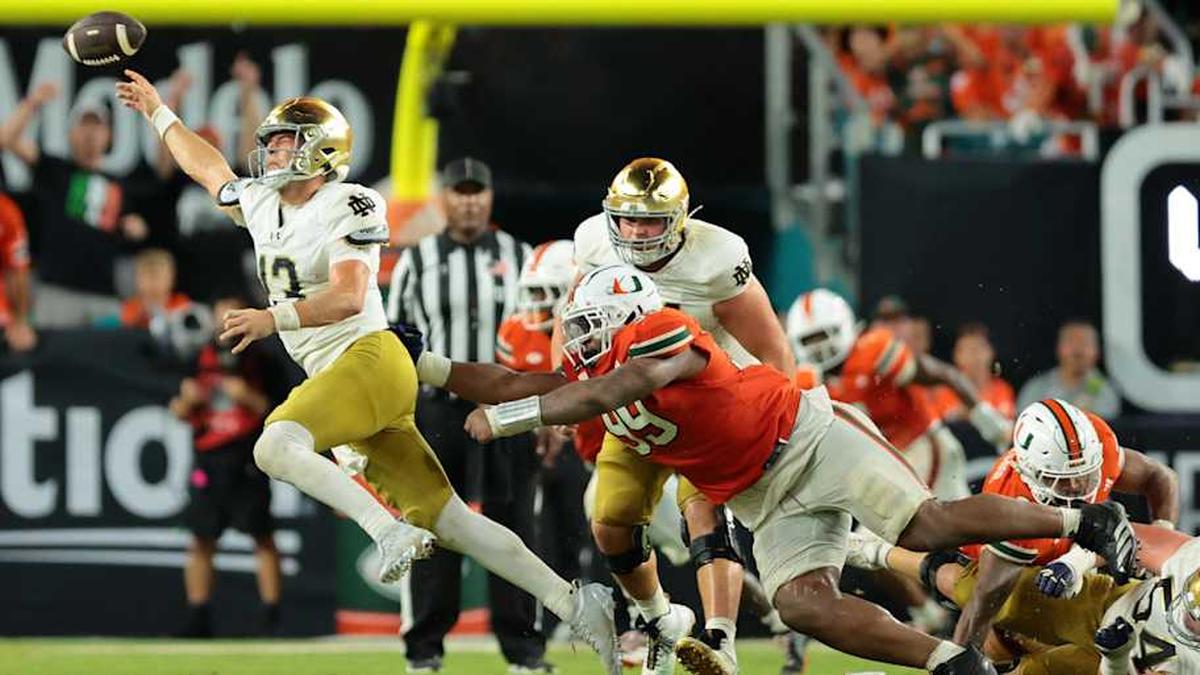  Aug 31, 2025; Miami Gardens, Florida, USA; Notre Dame Fighting Irish quarterback CJ Carr (13) throws the ball to avoid a sack against the Miami Hurricanes at Hard Rock Stadium. | Sam Navarro-Imagn Images 