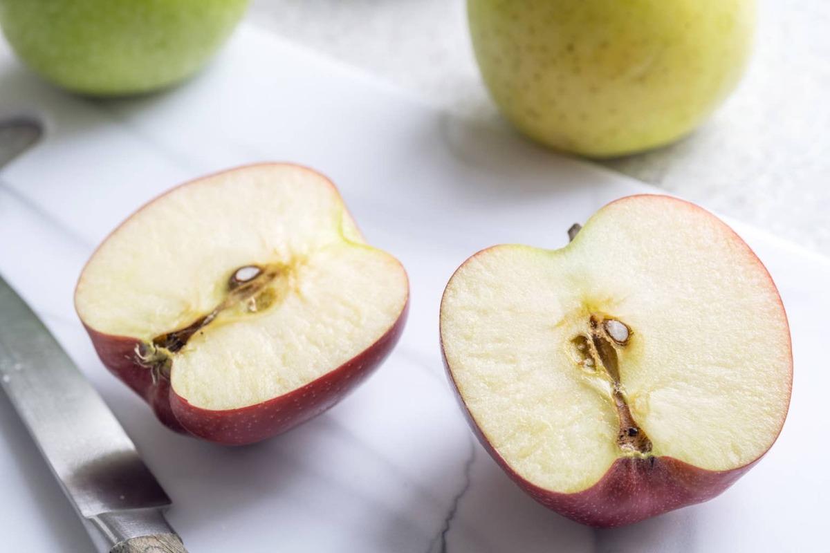  Two halves of a fresh apple cut down the middle.