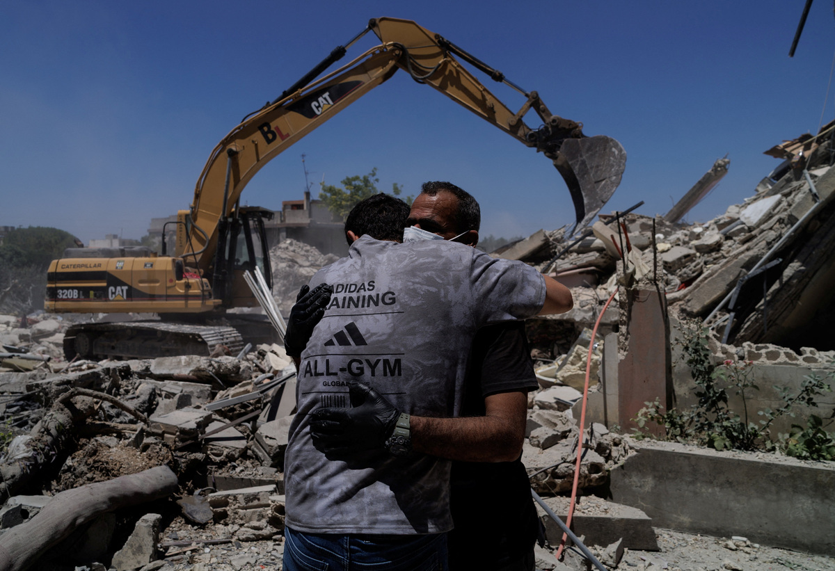 Rescuers embrace as they work at the site of an Israeli air strike in Barish, Tyre district, Lebanon, June 20, 2026.