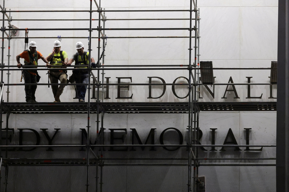 Workers stand on scaffolding ahead of removing lettering from the facade of the John F. Kennedy Memorial Center for the Performing Arts, following a federal judge’s order to remove U.S. President Donald Trump's name from the institution, in Washington, D.C., U.S., June 12, 2026. REUTERS/Jonathan Ernst