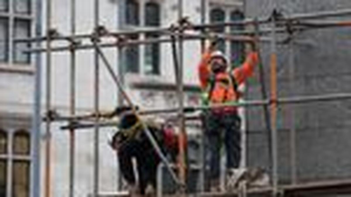 Construction workers work on a scaffolding at an office building, in London, Britain, January 16, 2025. REUTERS/Isabel Infantes