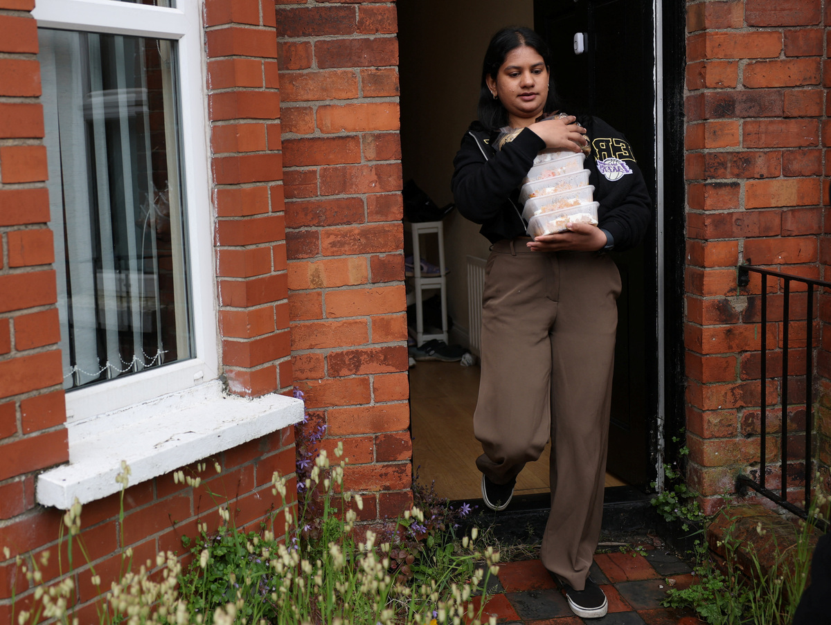 Ruchira Rangaprasad carries food containers to deliver to vulnerable migrants, following a knife attack on June 8, which left a man seriously injured and prompted police to declare it as a critical incident, in Belfast, Northern Ireland, June 11, 2026. REUTERS/Isabel Infantes