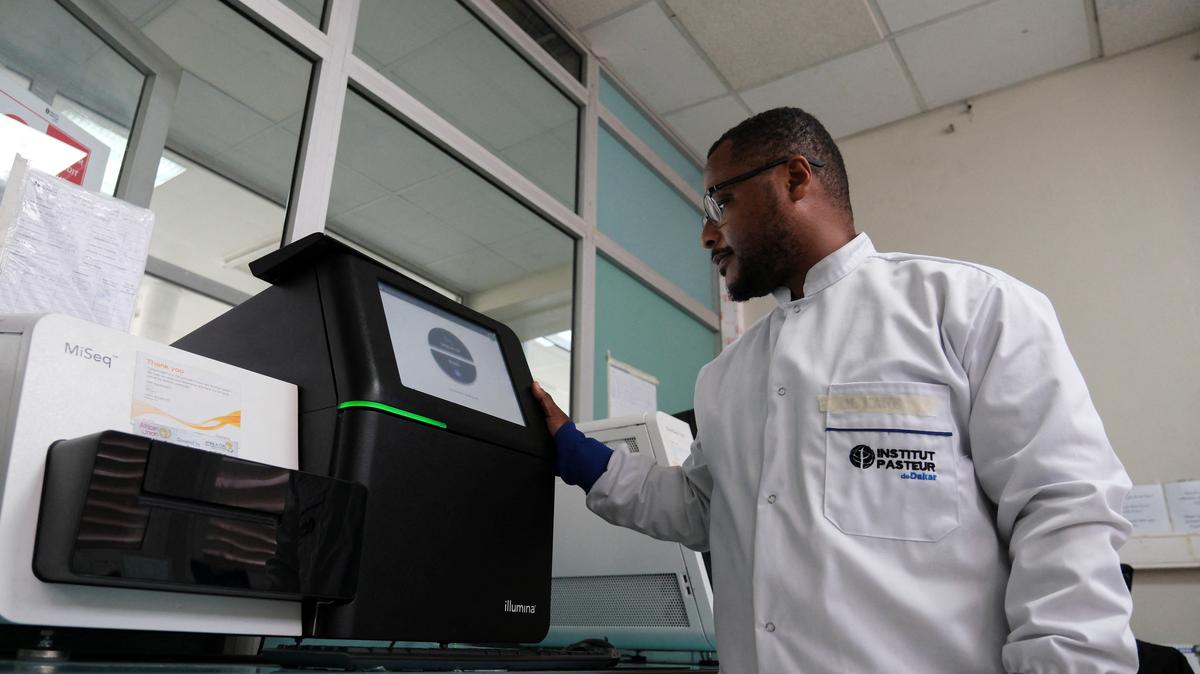 Dr. Moussa Moise Diagne, a virologist and head of the sequencing platform at Institut Pasteur, poses with one of the machines used to sequence the hantavirus genome during the coordinated response to the April 2026 outbreak, at Institut Pasteur in Dakar, Senegal, May 19, 2026. REUTERS/Ricci Shryock