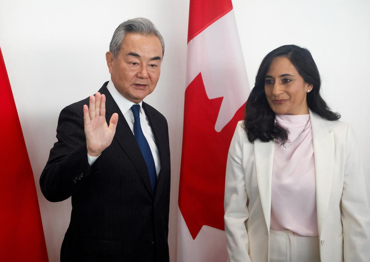 China's Foreign Minister Wang Yi waves during a photo-op with Canada's Foreign Affairs Minister Anita Anand in Ottawa, Ontario, Canada, May 29, 2026.  REUTERS/Patrick Doyle