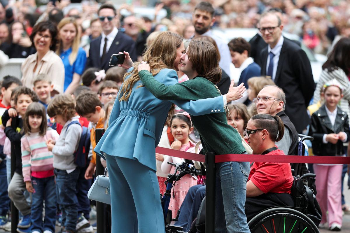 Britain's Catherine, Princess of Wales, embraces a girl while greeting people as she arrives outside the city hall, as part of a two-day visit to the region, in Reggio Emilia, Italy, May 13, 2026. REUTERS/Phil Noble/Pool