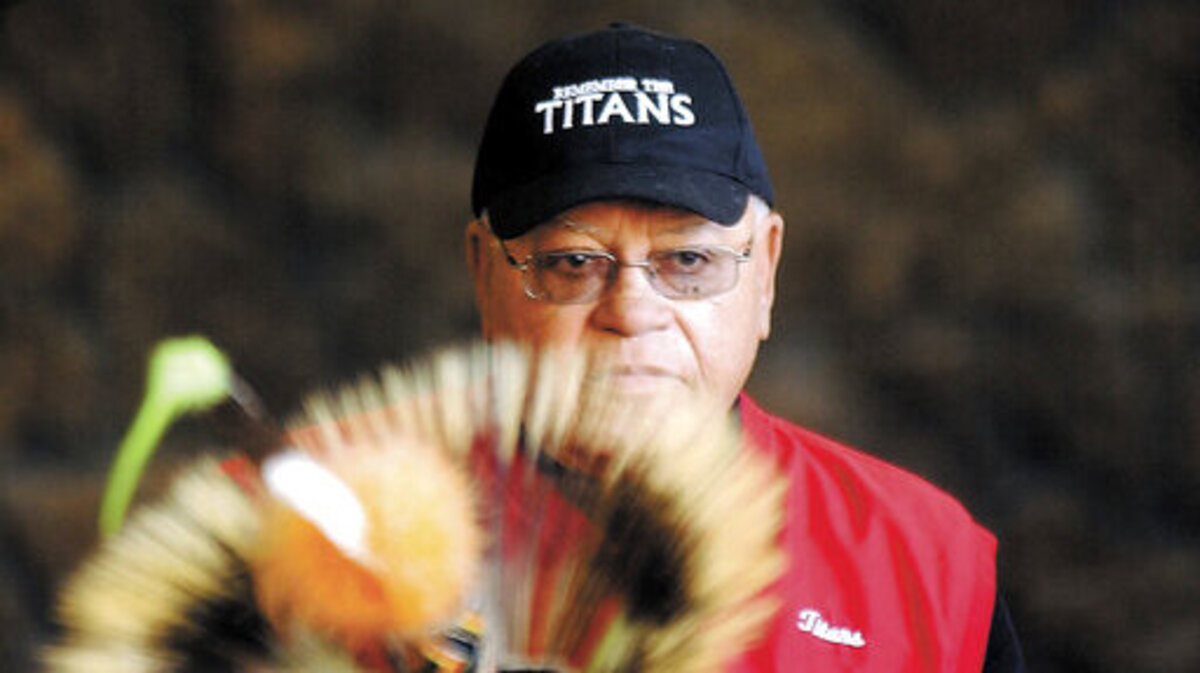 This Feb. 22, 2005, file photo shows Herman Boone, the coach featured in the movie “Remember the Titans,” peering over the headdress of a Shoshone-Bannock dancer to speak to a large crowd in Pocatello, Idaho. Boone, the Virginia high school football coach who inspired the movie “Remember the Titans,” has died. He was 84. Boone guided T.C. Williams High School to a state championship while navigating the early days of desegregation. Aly Khan Johnson, an assistant coach for Boone beginning in 1972, said the coach died Wednesday, Dec. 18, 2019, at his home In Alexandria, Virginia. Johnson said a funeral home operated by his wife is handling the arrangements, which are not complete.
