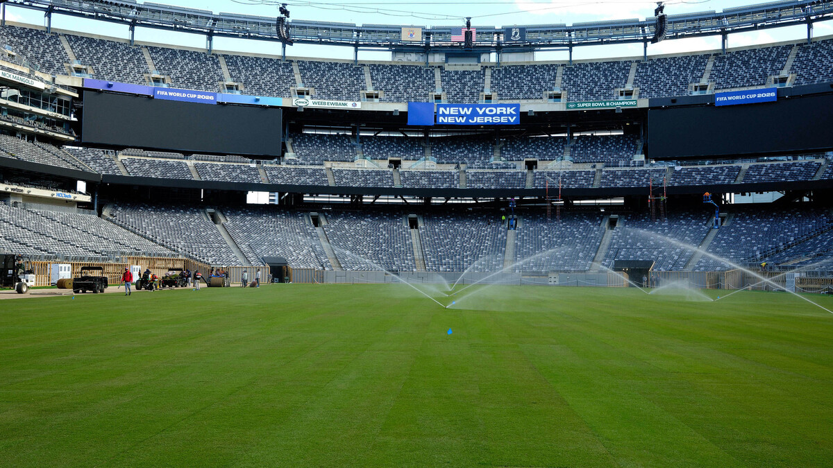 Workers water the newly installed pitch at New York New Jersey Stadium (temporarily renamed from MetLife stadium) ahead of the 2026 FIFA World Cup, in East Rutherford, New Jersey on May 7, 2026. (Charly Triballeau/AFP/Getty Images/TNS)