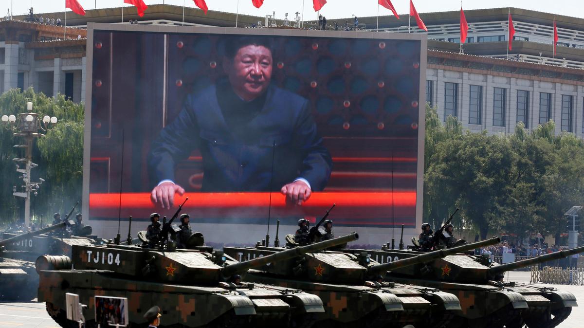ARCHIVO - En esta imagen de archivo del 3 de septiembre de 2015, el presidente de China, Xi Jinping, aparece en una pantalla mientras varios tanques de Tipo 99A2 participan en un desfile en memoria del 70mo aniversario de la rendición de Japón en la II Guerra Mundial, ante la Puerta de Tiananmen, en Beijing. (AP Foto/Ng Han Guan, Archivo)