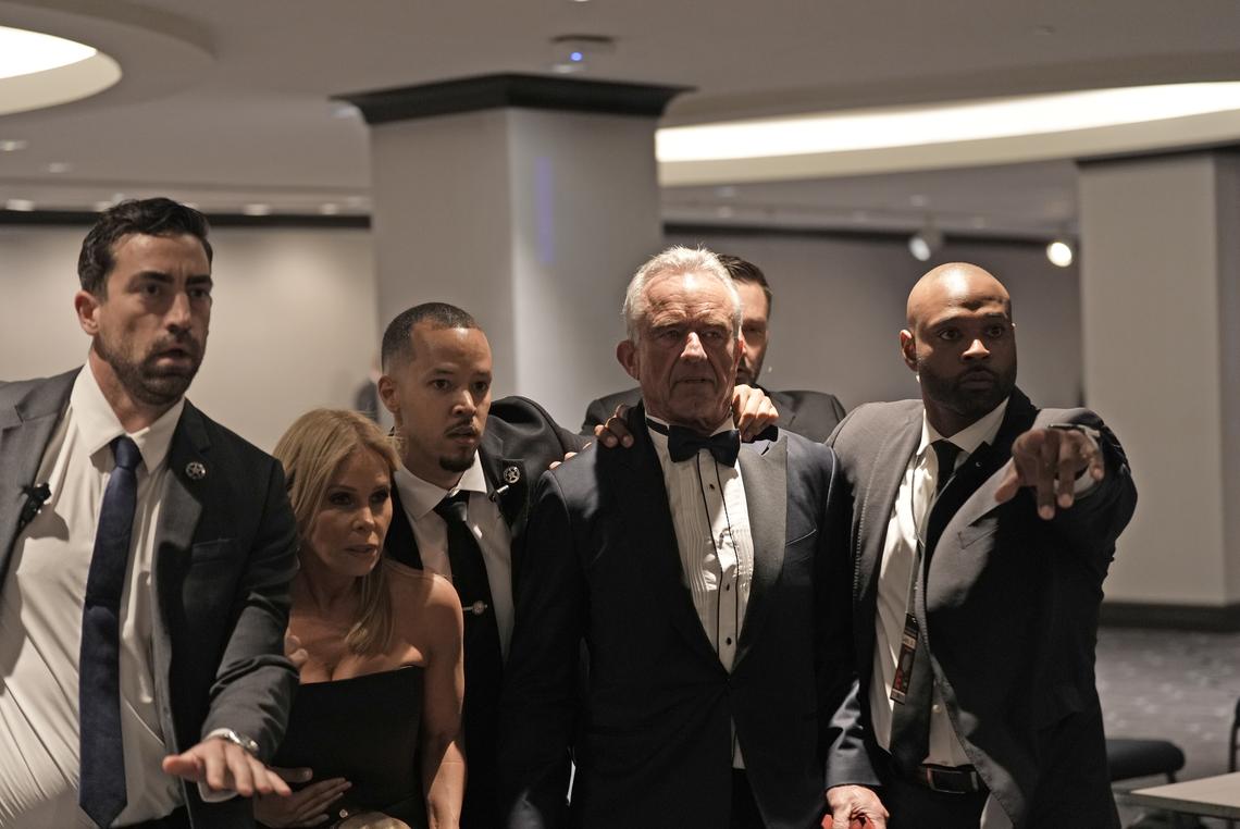 Health and Human Services Secretary Robert F. Kennedy Jr. and his wife Cheryl Hines are rapidly escorted out by security during the White House Correspondents' Association dinner is held, in Washington on Saturday, April 25, 2026. (Salwan Georges/The New York Times)