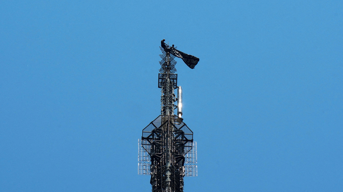 Two people display a banner as they stage a protest atop the Empire State Building in the Manhattan borough of New York, U.S., July 1, 2026.  REUTERS/Adam Gray