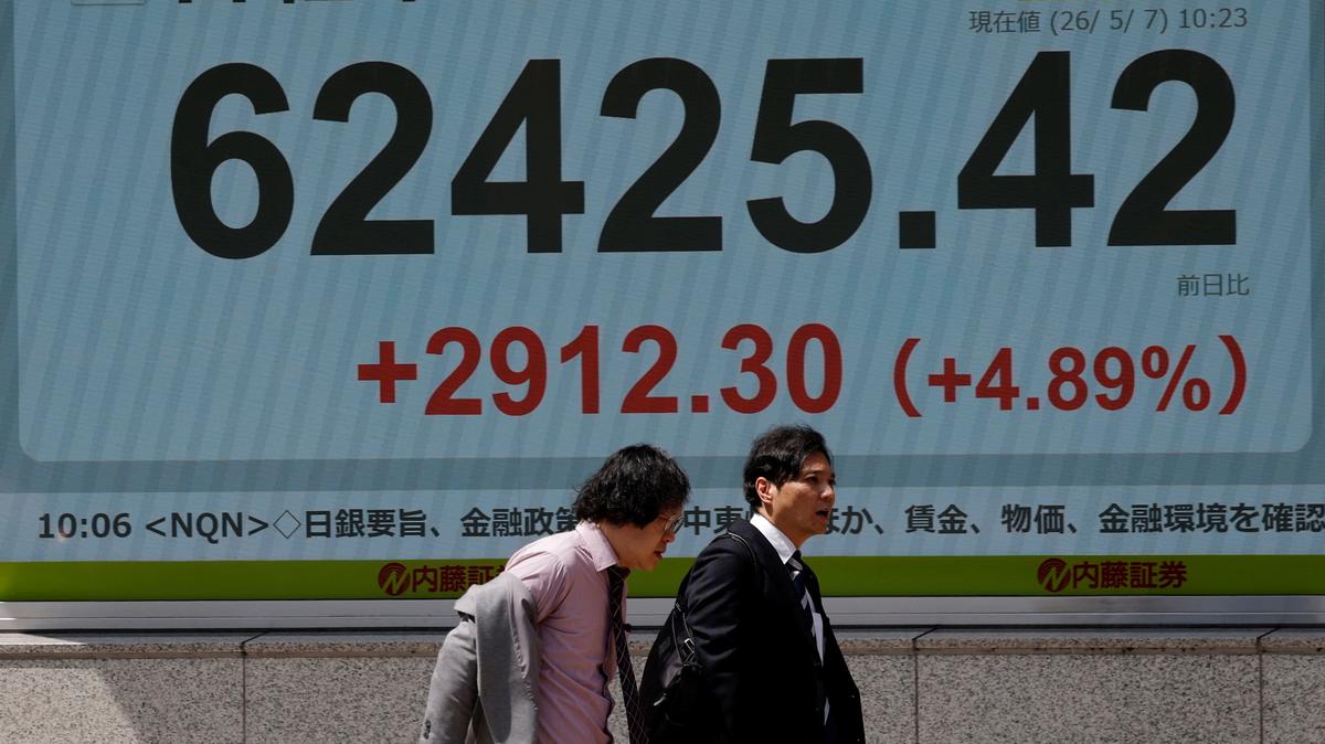 Pedestrians walk past a stock quotation board showing the Nikkei share average outside a brokerage in Tokyo, Japan, May 7, 2026. REUTERS/Kim Kyung-Hoon