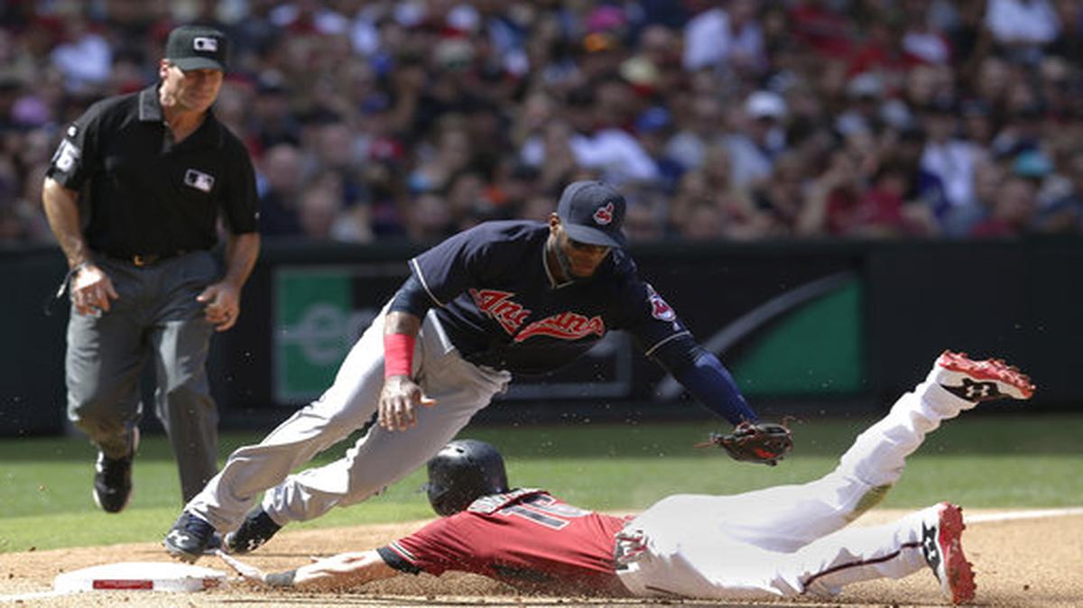 Yandy Díaz (izq.) trata de poner out en tercera base a Chris Owings, en un partido entre los Indios de Cleveland y los Diamondbacks de Arizona, el 9 de abril del 2017.
