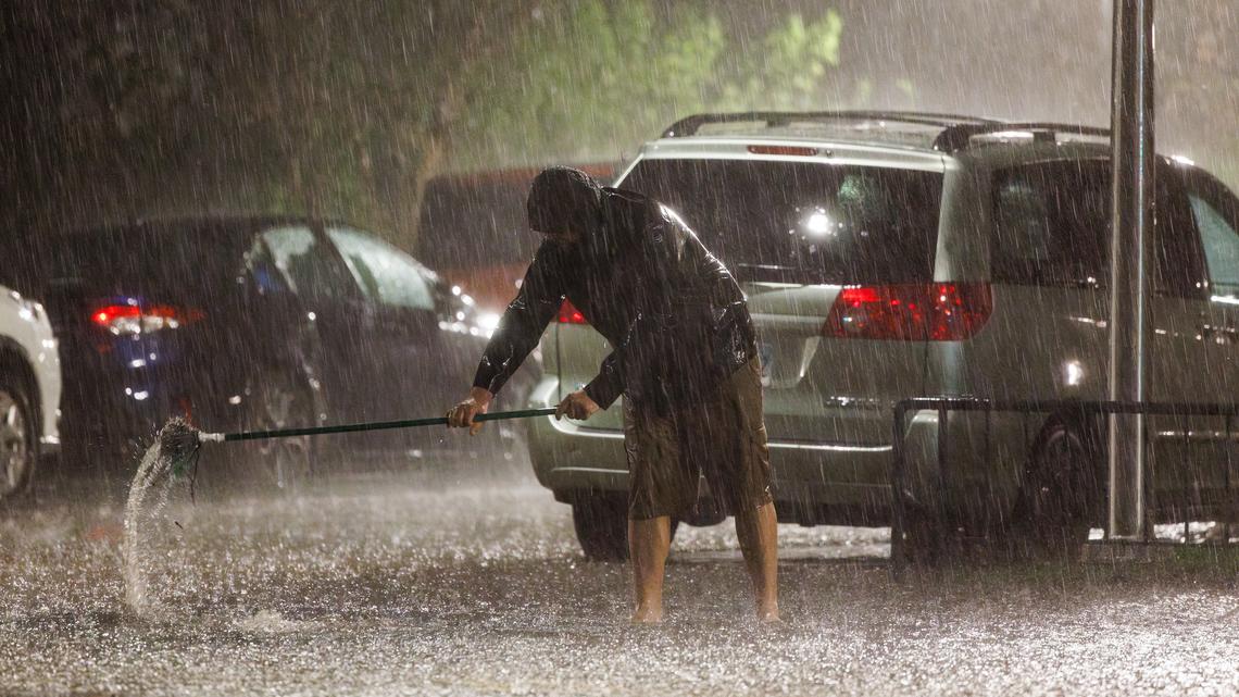 A person unclogs a drain in the Edgewater neighborhood as a storm system moves through the area, April 14, 2026, in Chicago. (Armando L. Sanchez/Chicago Tribune/TNS)
