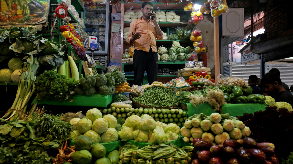 FILE PHOTO: Debashis Dhara, a vegetable vendor, speaks on his mobile phone at a retail market area in Kolkata, India, March 22, 2022. Picture taken March 22, 2022. REUTERS/Rupak De Chowdhuri/File Photo