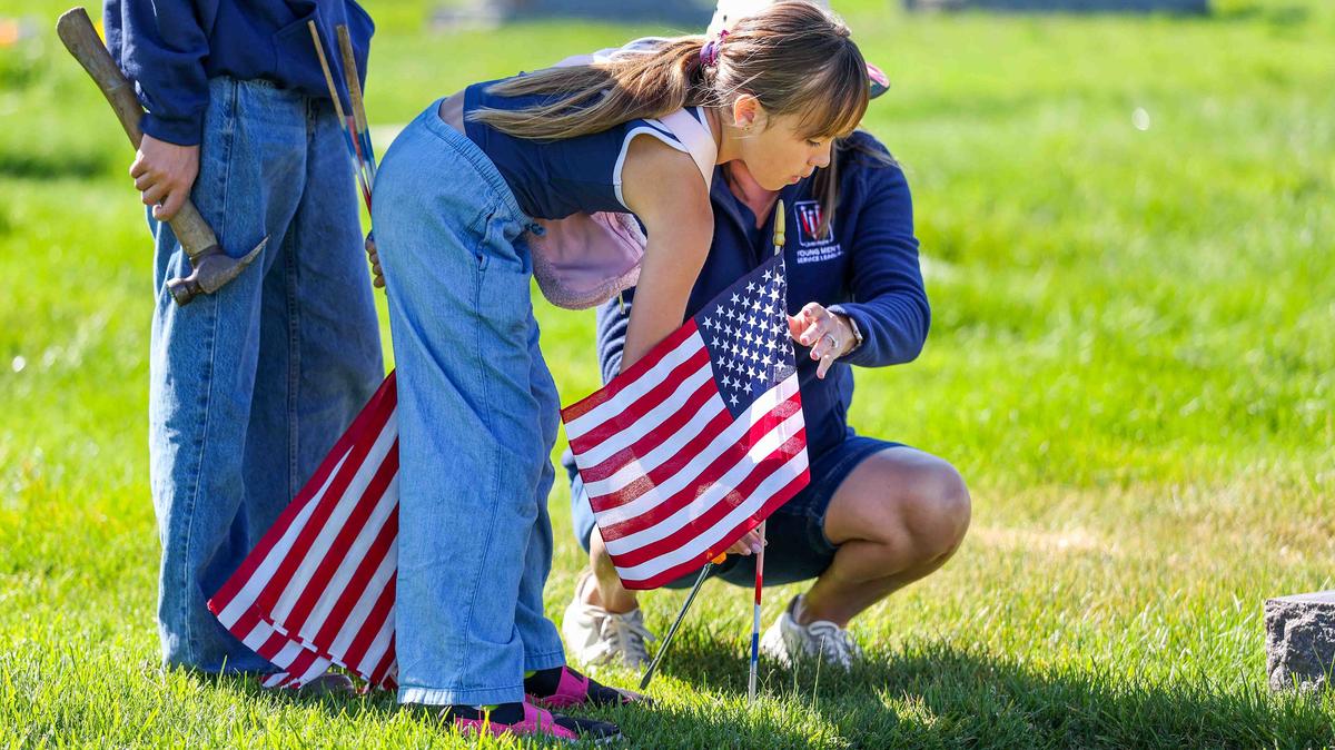 Daphne Eddy, 8, her mother, Rhiannon Eddy, and her brother, Grant, 13, place American flags on the gravestones of fallen soldiers for Memorial Day weekend at Memory Garden Cemetery in Livermore, Calif., Saturday, May 23, 2026. About 120 mother-and-son teams from the Livermore chapter of the Young Men’s Service League, in partnership with members of American Legion Post 47, took part in the annual event at Memory Garden Cemetery and St. Michael’s Cemetery. (Ray Chavez/Bay Area News Group)