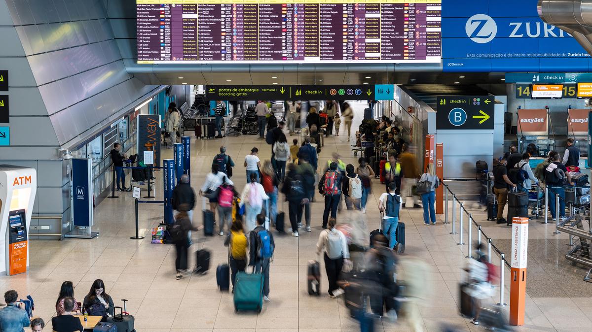 Passengers walk in a hall at the Humberto Delgado Airport in Lisbon on April 2, 2025.  (Henrique Casinhas/AFP/Getty Images/TNS)