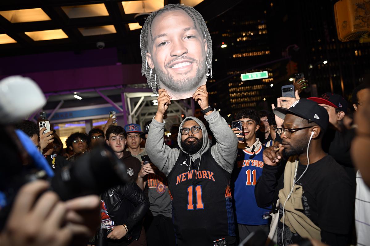 Jubilant Knicks fans, including one holding a cardboard cutout depicting Jalen Brunson, celebrate outside Madison Square Garden in New York after their team swept the Cleveland Cavaliers in the Eastern Conference Finals to advance to the NBA Finals for the first time since 1999 on Monday night, May 25, 2026. Thousands of fans blocked traffic outside Madison Square Garden, even though the game was in Ohio and the outdoor watch parties at the Garden had been suspended because of rowdy fans. (Vincent Alban/The New York Times)