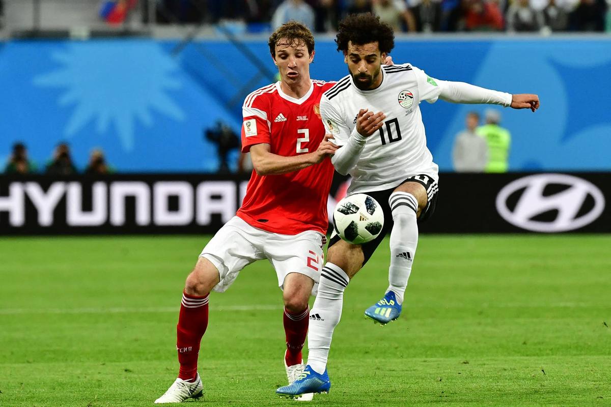  Egypt's forward Mohamed Salah (R) vies with Russia's defender Mario Fernandes during the Russia 2018 World Cup Group A football match between Russia and Egypt at the Saint Petersburg Stadium in Saint Petersburg on June 19, 2018. (Photo by Giuseppe CACACE / AFP via Getty Images) / Photo by Giuseppe CACACE / AFP via Getty Images) /