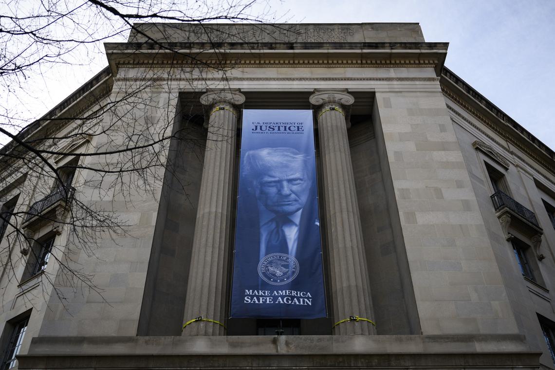  A a new banner featuring an image of US President Donald Trump is displayed on the facade of the US Department of Justice headquarters, in Washington, DC, February 20, 2026. 