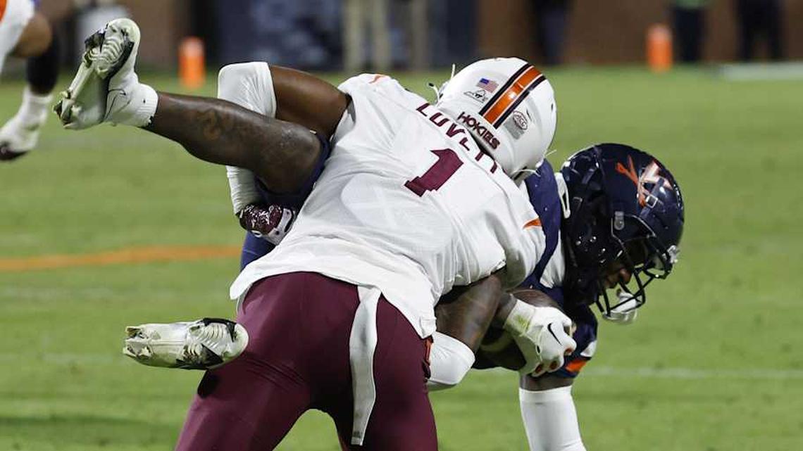  Nov 25, 2023; Charlottesville, Virginia, USA; Virginia Cavaliers wide receiver Malik Washington (4) is tackled by Virginia Tech Hokies cornerback Dante Lovett (1) during the third quarter at Scott Stadium. Mandatory Credit: Geoff Burke-Imagn Images | Geoff Burke-Imagn Images 