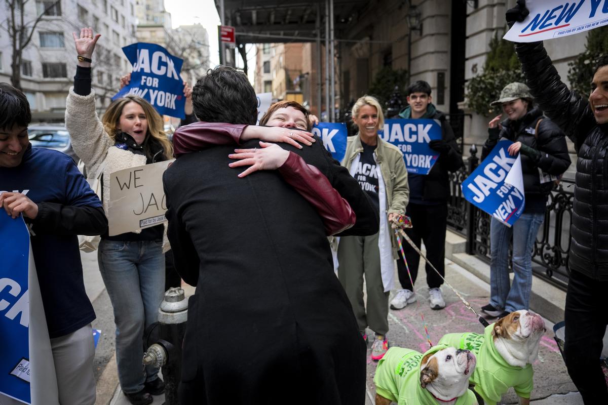 FILE -- Jack Schlossberg, back to camera, who is running for the seat held by the outgoing Rep. Jerrold Nadler (D-N.Y.), is embraced by a supporter as he arrives for a candidates forum in Manhattan on March 17, 2026. Nadler and Rep. Nancy Pelosi (D-Calif.) are retiring, prompting competitive races to succeed them. Whoever wins their seats could tap big donors and shape the Democratic Party. (Vincent Alban/The New York Times)