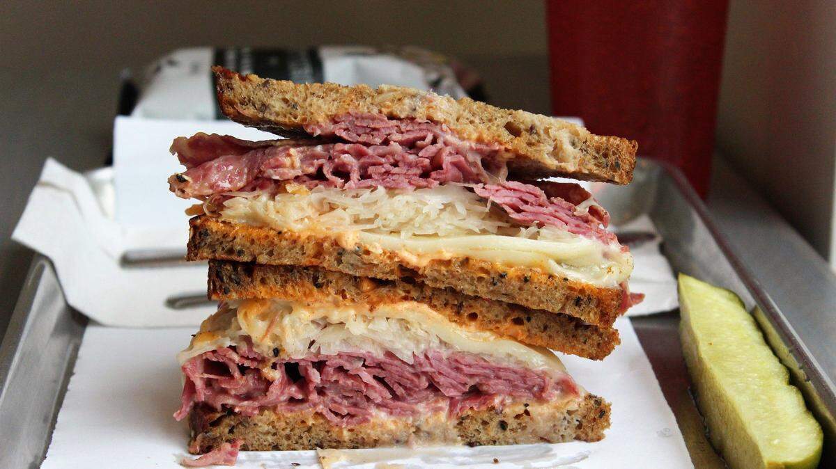 A Reuben sandwich includes shaved corned beef with a simple cabbage slaw, homemade Thousand Island dressing and a slice of Swiss cheese.