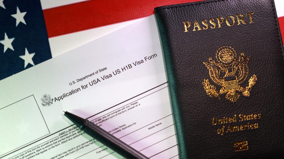 A U.S. flag, a passport and a U.S. H-1B Visa application form are seen in this illustration taken, September 22, 2025. REUTERS/Dado Ruvic/Illustration