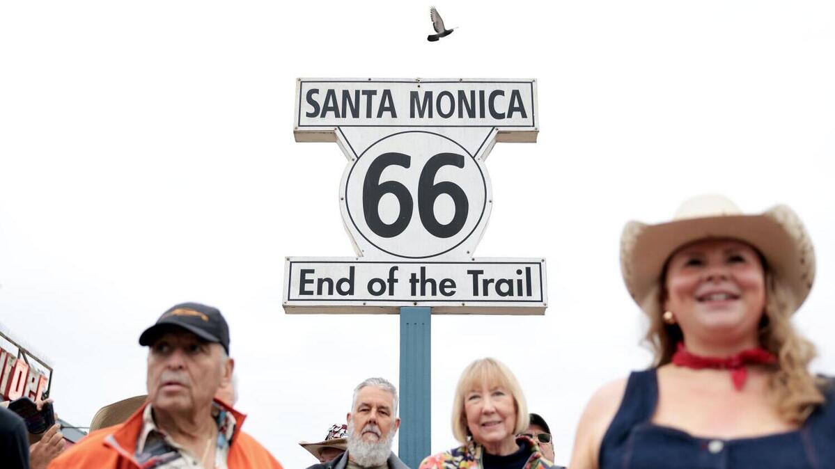 SANTA MONICA, CA - June 6, 2026: Participants in a caravan from Santa Monica Pier to Chicago gather at the sign on the Santa Monica Pier to kick off the trip, in celebration of the centennial of Route 66, on Saturday, June 6, 2026. (Christina House / Los Angeles Times)