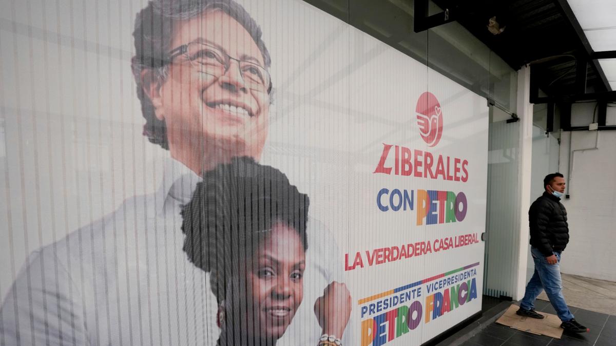 Un hombre camina cerca de una pancarta de campaña del candidato presidencial de la coalición Pacto Histórico, Gustavo Petro y su compañera de fórmula Francia Márquez, antes de la segunda vuelta de las elecciones el domingo, en Bogotá, Colombia, el lunes 13 de junio de 2022.